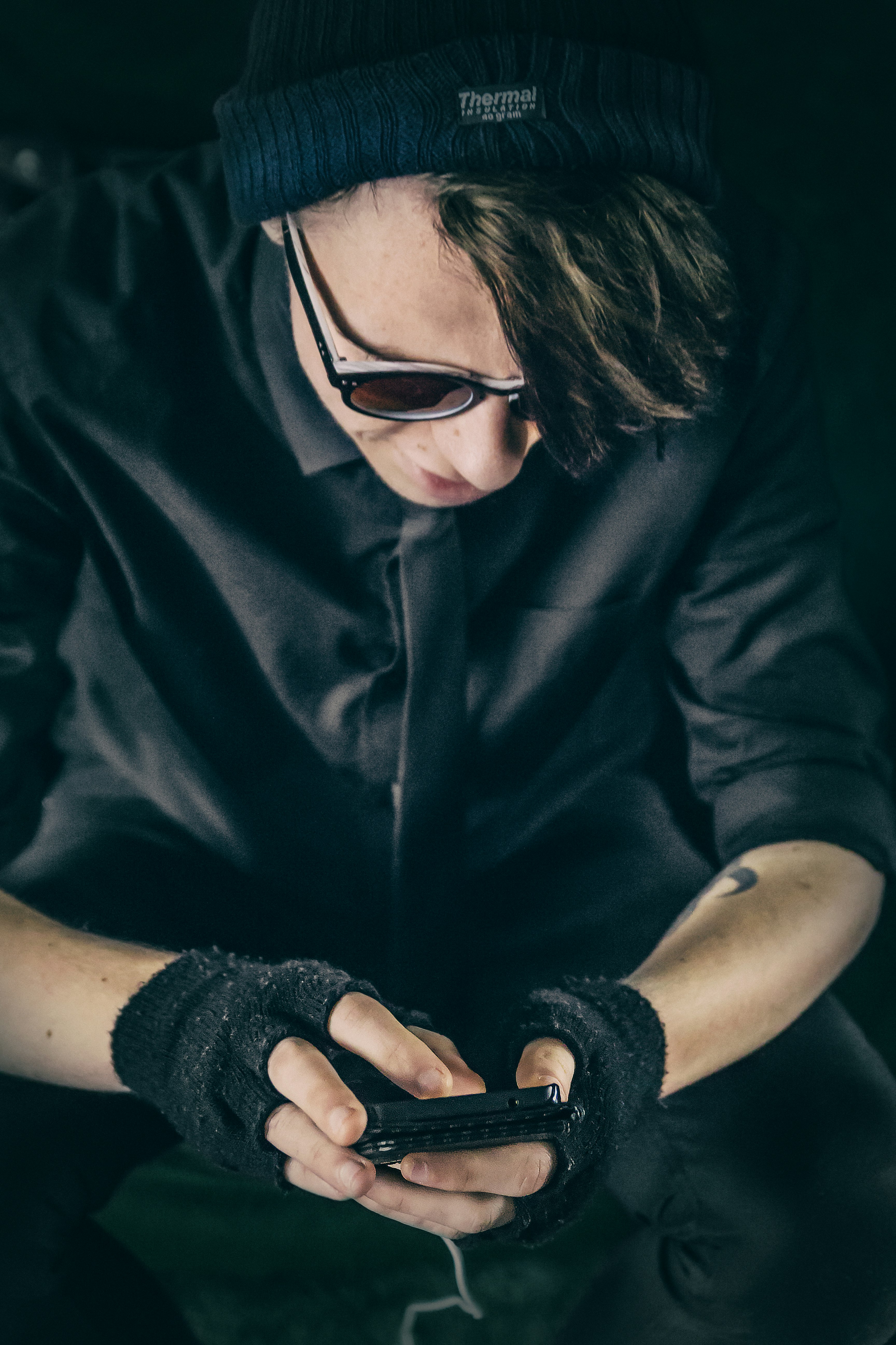 man wearing black top using smartphone